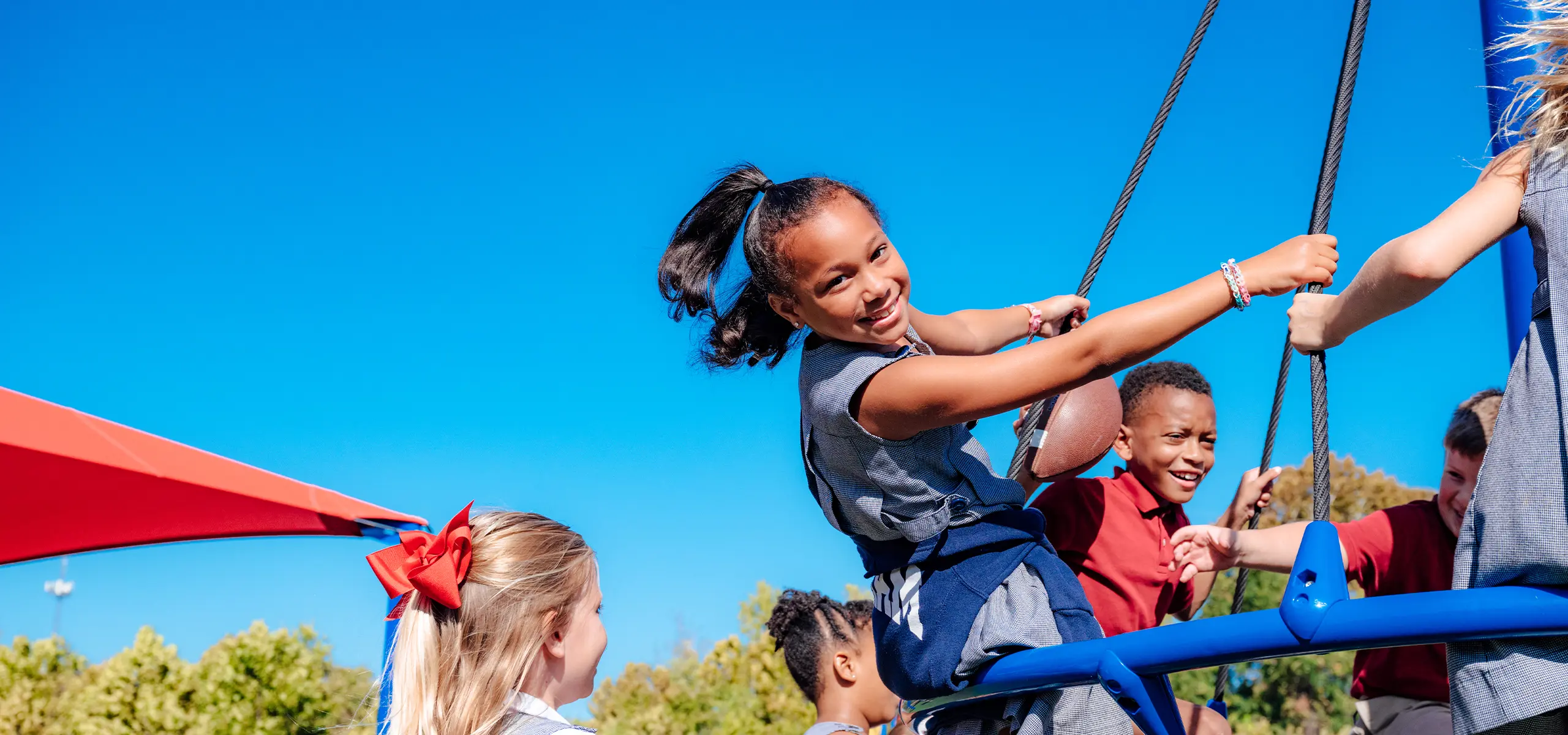 Lower school girl playing on new playground.