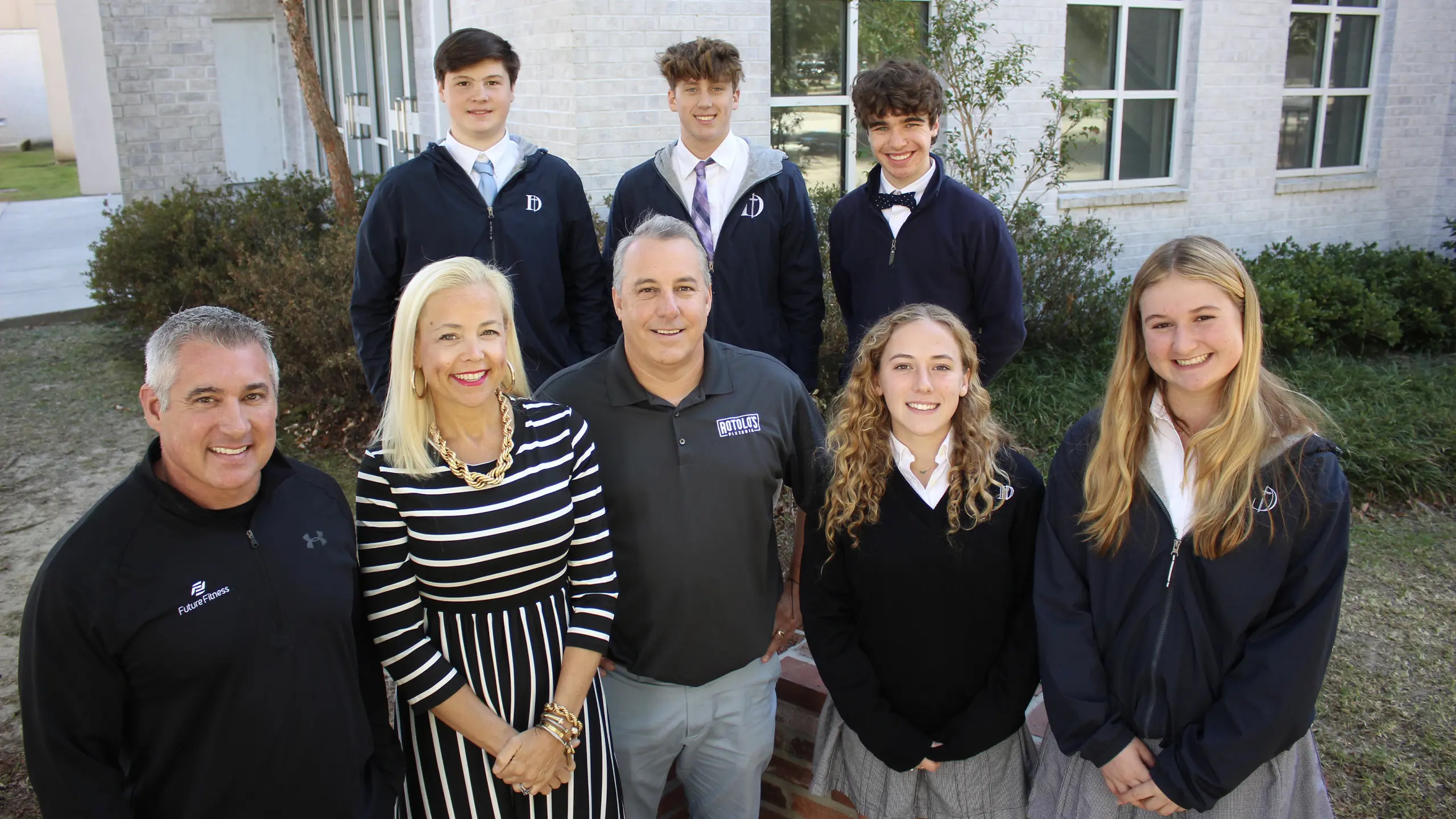 Three business executives standing with Dunham students after a Professional Experience Program lunch and learn session