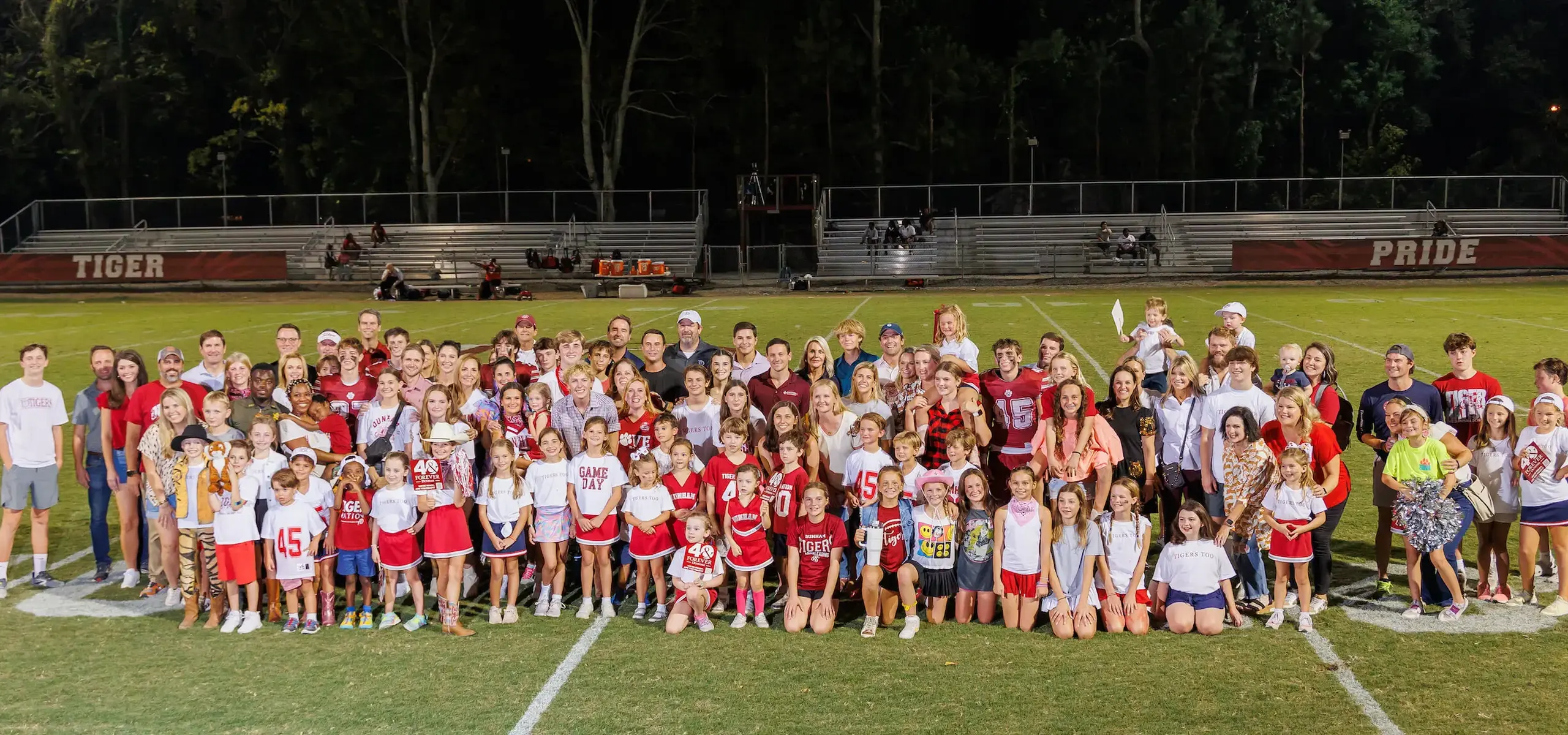 Dunham alumni with their kids on the football field