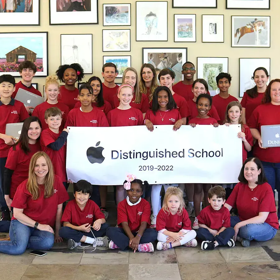 Dunham students and Dunham staff holding Apple MacBooks celebrating 7 time Apple Distinguished School award.