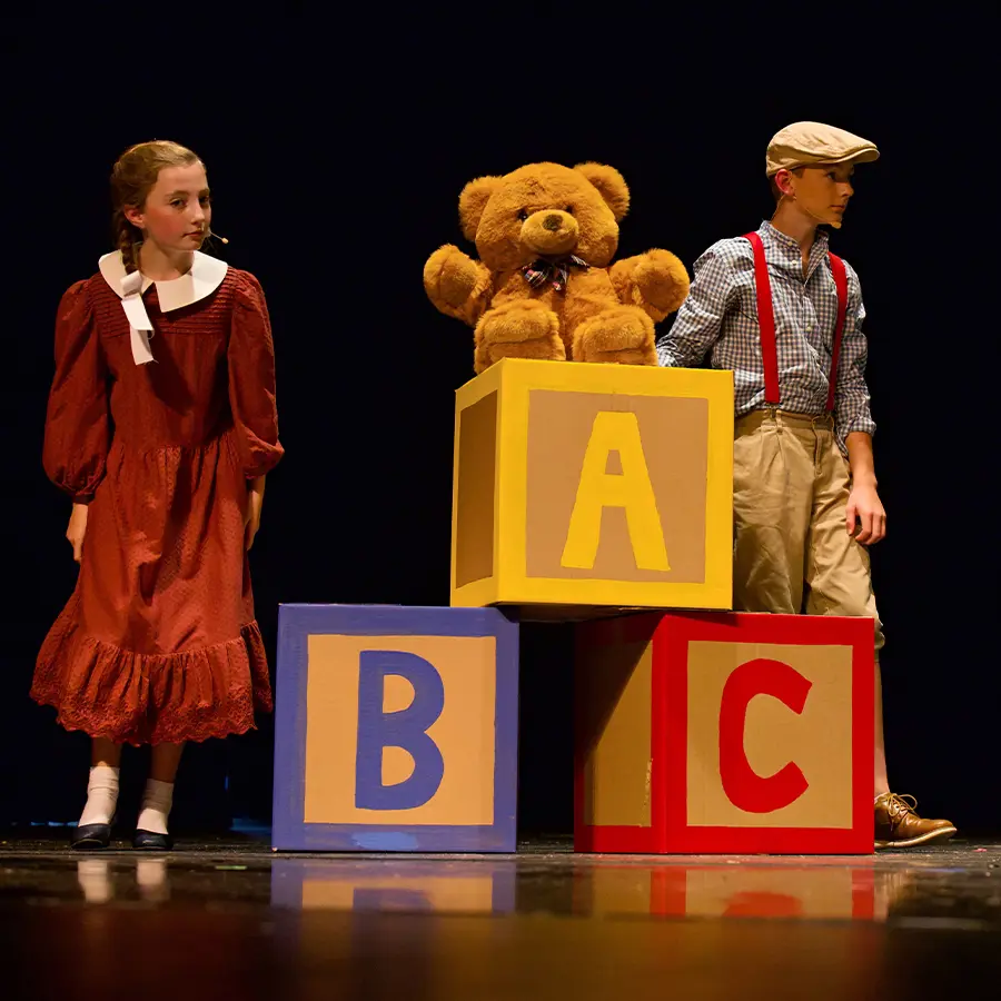 Two Middle School performers acting during musical.