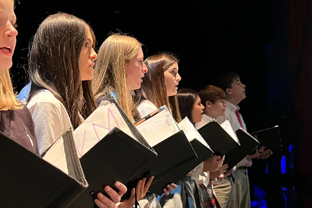 Dunham choir performing on stage at event.