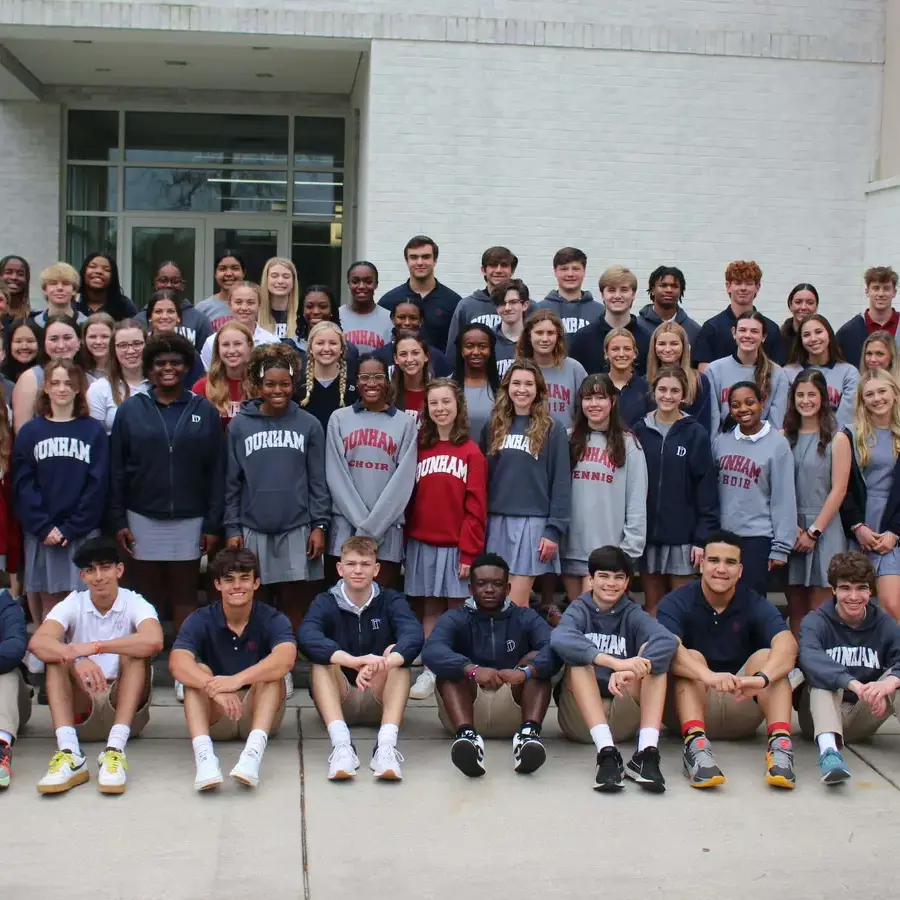 Large group of Dunham high school students smiling for a photo in front of the Brown-Holt Chapel Arts Center