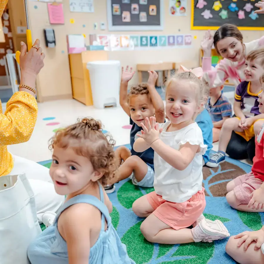 Dunham early childhood students smiling while learning with teacher 