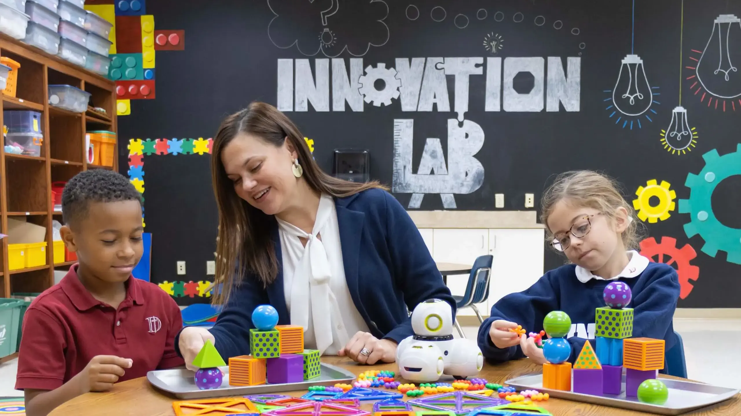 Dunham elementary school boy and girl working with a teacher on STEM projects in the Innovation Lab.