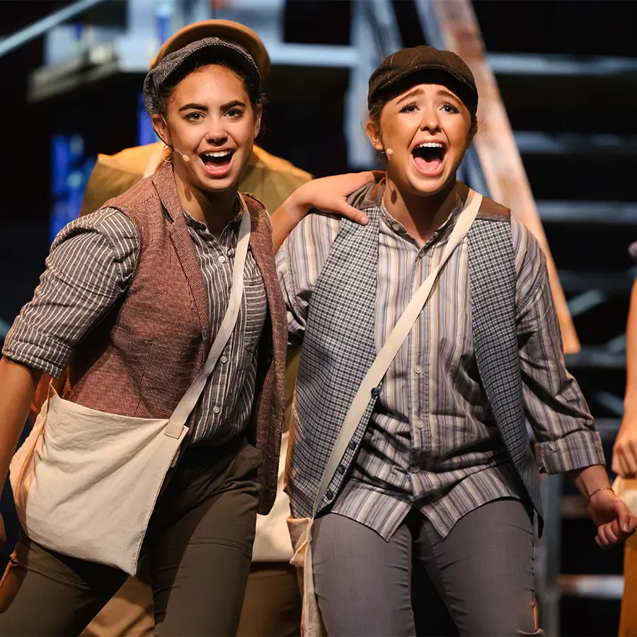 Two student actresses performing in upper school musical.