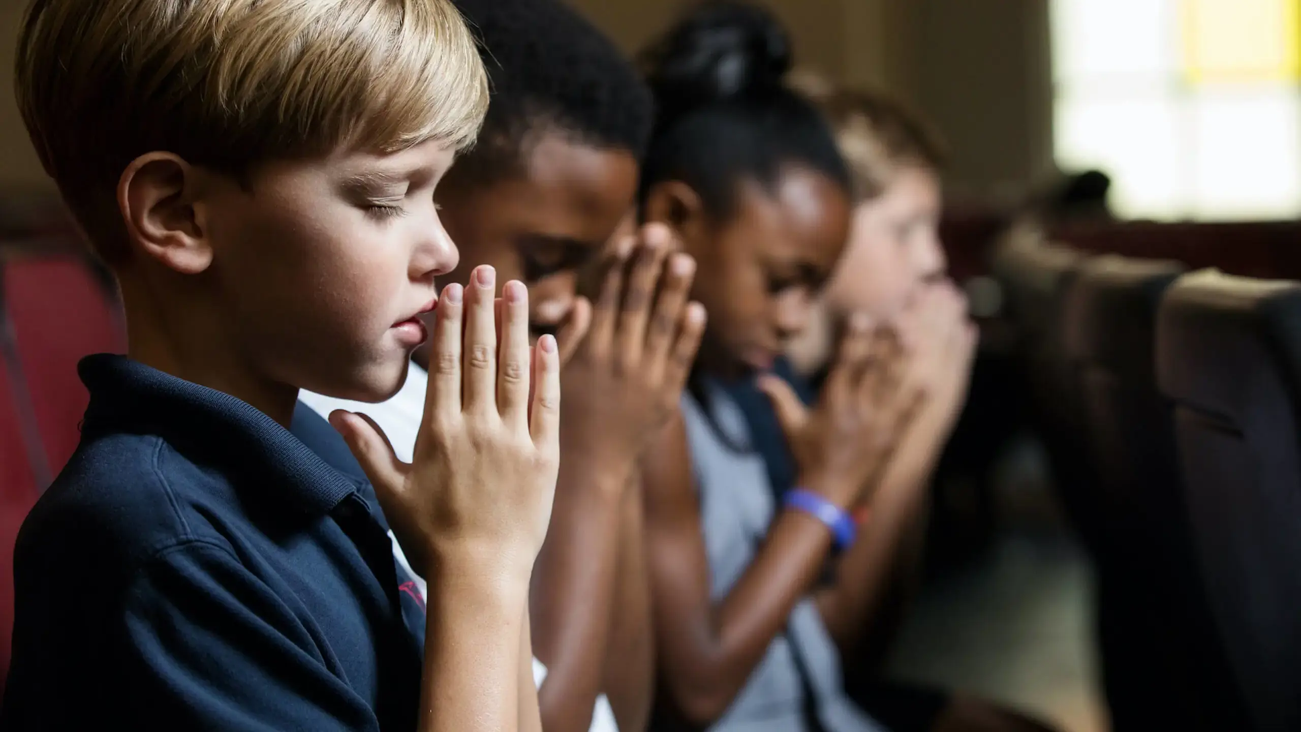 Elementary school students praying in chapel